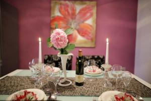 un tavolo con un fiore rosa in un vaso e candele di Apartment Julija a Zara (Zadar)