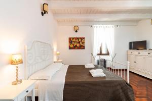 1 dormitorio blanco con 1 cama grande y TV en Villa Carolina, en San Corrado di Fuori