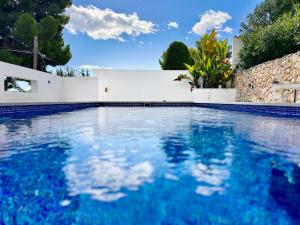 una piscina con acqua blu e una recinzione bianca di Perla Blanca by Sun & Sea Homes a Benissa