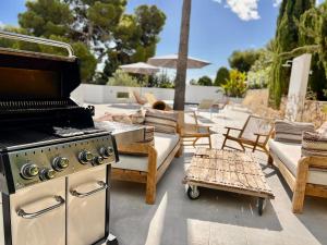 un patio esterno con barbecue, sedie e tavoli di Perla Blanca by Sun & Sea Homes a Benissa