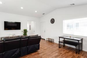 a living room with a black couch and a table at Entire Guesthouse for Rent in San Bernardino in San Bernardino