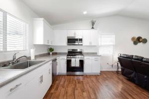 a kitchen with white cabinets and a sink and a stove at Entire Guesthouse for Rent in San Bernardino in San Bernardino