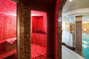 a bathroom with red glass doors and a swimming pool at Villa Drago Spa in Donnalucata +34 photos