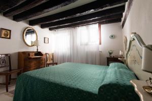 威尼斯的住宿－聖賈科莫度假屋，一间卧室配有绿色的床和梳妆台