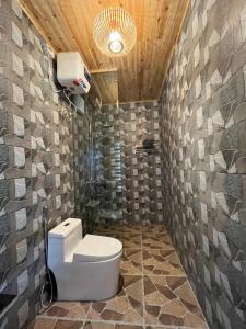 La salle de bains est pourvue de toilettes et d'un mur en pierre. dans l'établissement Tavanparadise homestay, à Sa Pả