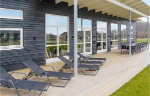a deck with chairs and tables on a house at Awesome Home In Haderslev With 4 Bedrooms, Sauna And Wifi in Knud