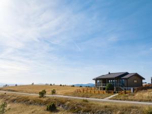 una casa sul fianco di una collina con un cielo di Vila Cigota Zlatibor a Zlatibor