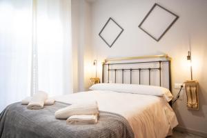 ein Schlafzimmer mit einem Bett mit zwei Handtüchern darauf in der Unterkunft WISH SUITE TORRES DE SEVILLA in Sevilla