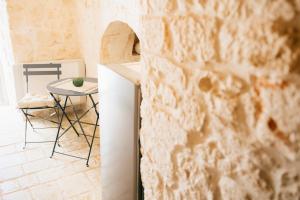 a kitchen with a table and a chair in a room at Borgo Chiancarosa, esclusivi trulli con piscina riscaldata in Putignano