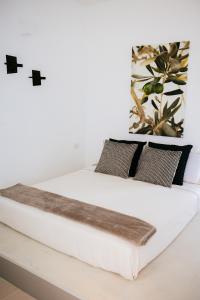 - une chambre avec un lit blanc et des oreillers noirs dans l'établissement Borgo Chiancarosa, à Putignano