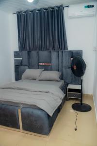 Budget Bliss Suites في بنين سيتي: سرير مع اللوح الأمامي الأسود في الغرفة