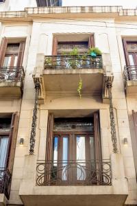 un edificio con balcone e piante sopra di El Templario Hostel a Buenos Aires