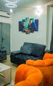 a living room with a couch and a painting on the wall at Budget Bliss Suites in Benin City