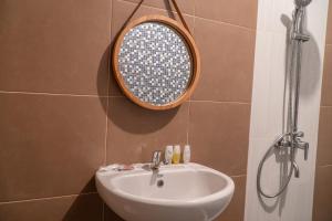 een badkamer met een wastafel en een spiegel aan de muur bij Villa Dangka in Kubupenlokan