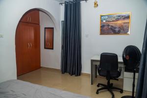 a bedroom with a bed and a desk and a chair at Budget Bliss Suites in Benin City