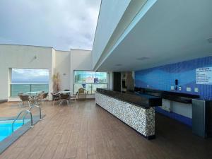 a large room with a swimming pool and a dining area at Ocean Flat 606 in Vila Velha
