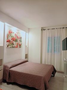 ボローニャにあるAffittacamere Rizzoliのベッドルーム1室(ベッド1台付)が備わります。壁には絵画が飾られています。