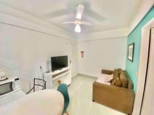 a living room with a couch and a tv at Ocean Flat 606 in Vila Velha