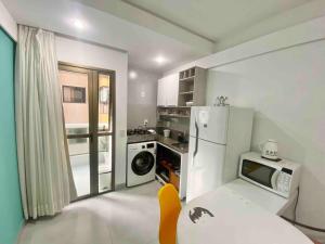 a kitchen with a white refrigerator and a microwave at Ocean Flat 606 in Vila Velha