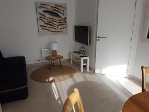 détente gite et spa entre mer et marais في Bourgneuf-en-Retz: غرفة معيشة مع أريكة وتلفزيون