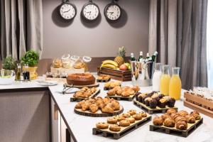 a buffet with many different types of pastries and clocks at Tapestry by Hilton Ambasciatori Hotel in Mestre