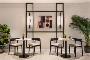 una sala da pranzo con due tavoli e sedie di Tapestry by Hilton Ambasciatori Hotel a Mestre