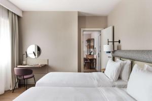 Letto o letti in una camera di Tapestry by Hilton Ambasciatori Hotel