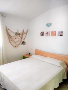 a bedroom with a white bed and pictures on the wall at Affittimoderni Santa Maria Coghinas in Santa Maria Coghinas