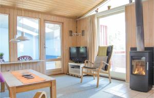 HejlsにあるNice Home In Hejls With 3 Bedrooms, Wifi And Indoor Swimming Poolのリビングルーム(暖炉、テレビ付)