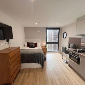 a bedroom with a bed and a desk and a kitchen at Aberdeen by Charles Hope in Aberdeen