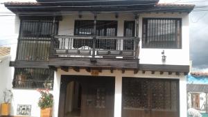 a building with a balcony on the side of it at SANTA HELENA HOSPEDERIA in Tibasosa