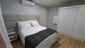 um quarto com uma grande cama branca e uma janela em Studio Praia do Jardim 1 305B em Angra dos Reis