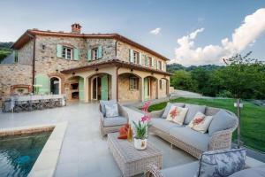 un patio al aire libre con piscina y una casa en Villa Grema, a Farmhouse with Infinity Pool, en Loppeglia