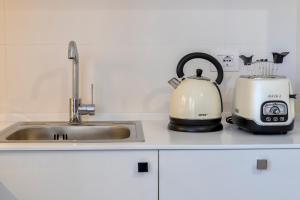 a tea kettle and toaster sitting on a kitchen counter at RelaisApartments Centro in Alghero