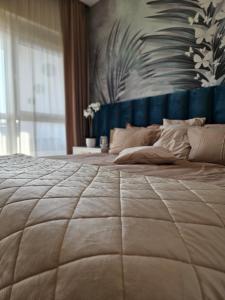 duże łóżko w sypialni z dużą narzutą w obiekcie The One Apartment Fruške Residence w mieście Vrdnik