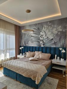 The One Apartment Fruške Residence في فردنيك: غرفة نوم مع سرير كبير مع اللوح الأمامي الأزرق