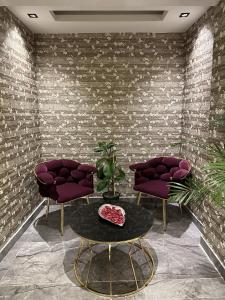 een kamer met 2 paarse stoelen en een tafel bij Bloomtalya Hotel in Antalya
