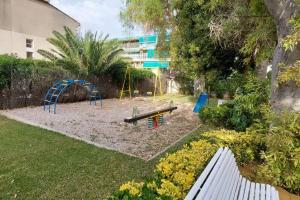 a park with a bench and a playground at Apartamento, piscina y playa in Grao de Castellón
