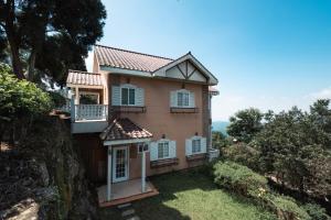 een huis met een balkon en een tuin bij Chill hill cottage in Taiping