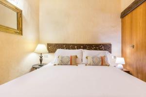 ヴィッラシミーウスにあるLuna Bay Home Retreat con vista sulla baia di Porto Luna a 2 km da Villasimiusの大きな白いベッドと枕が2つある寝室