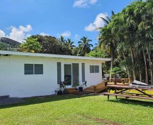 a white house with a picnic table in the yard at Muri Villas in Rarotonga