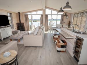 a kitchen and living room with a couch and a table at 1 Delamere Point in Northwich