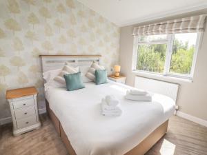 a bedroom with a large white bed and a window at 40 Delamere Point in Northwich