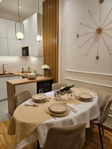 a dining room with a table and a kitchen at The One Apartment Fruške Residence in Vrdnik