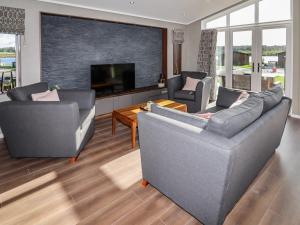 a living room with two couches and a flat screen tv at 28 Delamere Point in Northwich