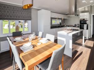 a kitchen and dining room with a wooden table and chairs at 28 Delamere Point in Northwich