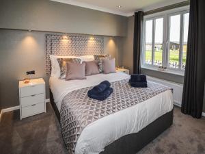 a bedroom with a large bed with a large window at 28 Delamere Point in Northwich