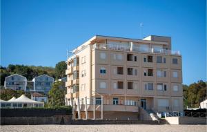 a building on the beach with houses in the background at Awesome Apartment In Ortona With Wifi in Ortona +7 photos