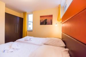 um quarto com uma cama com lençóis brancos e toalhas em Kölpinsee 03 em Eldenburg