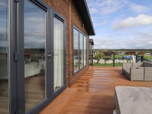 a patio with sliding glass doors and wooden floors at 44 Delamere Point in Northwich